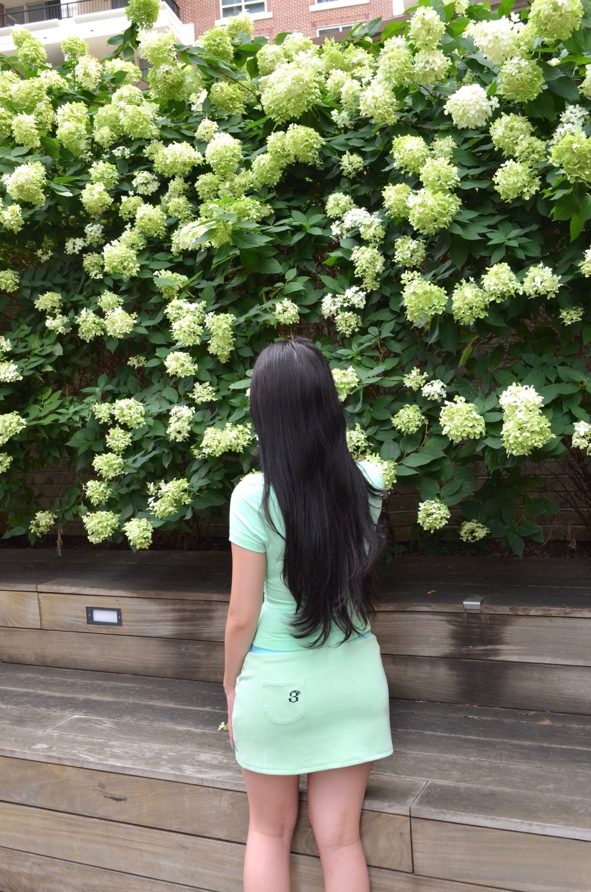 Model wearing Nel set back view, mint mock-neck shirt and mini skirt, Espada collection