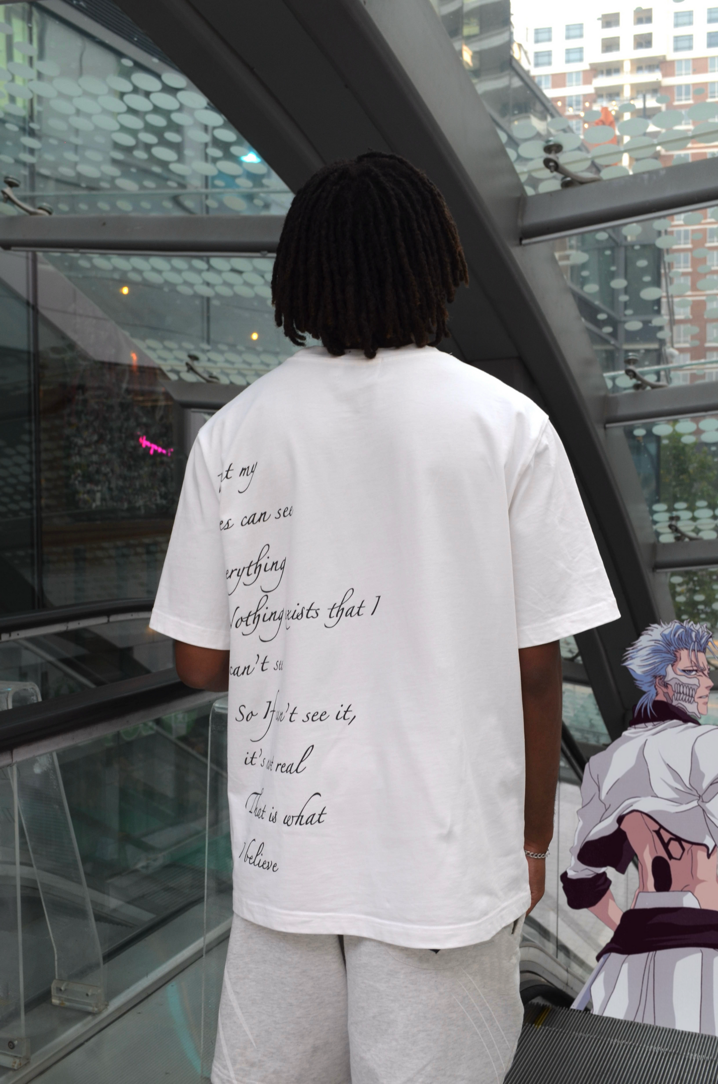 Model wearing Ulquiorra shirt back view, hollow hole graphic and handwritten monologue print